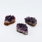 Three purple crystal formations on a white background