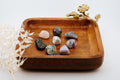 Wooden tray with decorative elements and stones on a white background