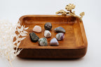 Wooden tray with decorative elements and stones on a white background