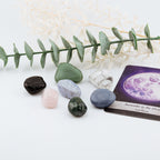 Set of stones and a tarot card with a purple design on a white background