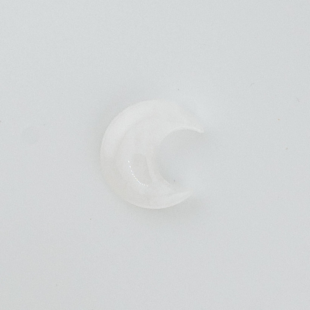 Clear moon-shaped crystal on a white background