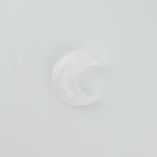 Clear moon-shaped crystal on a white background