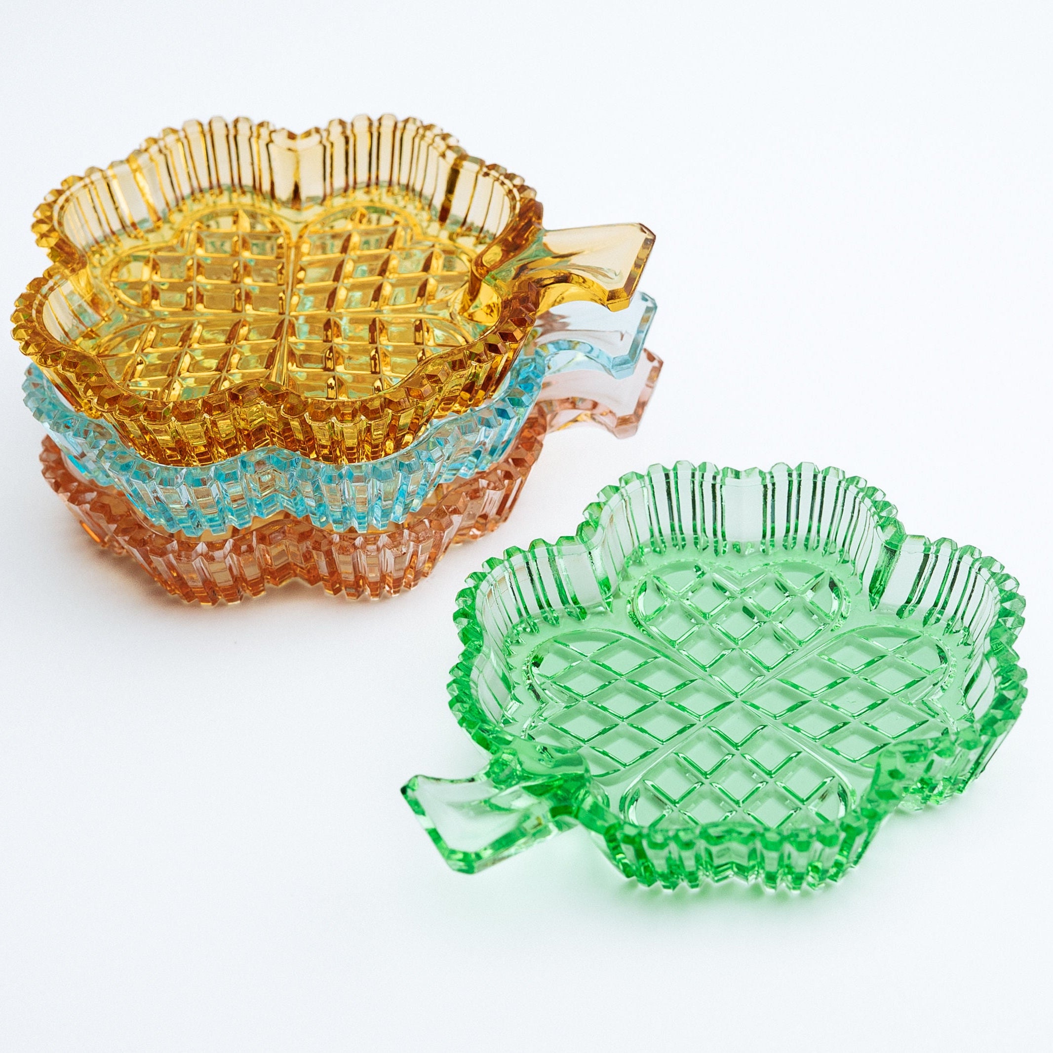 Clover shaped dishes in multiple colors on a white background
