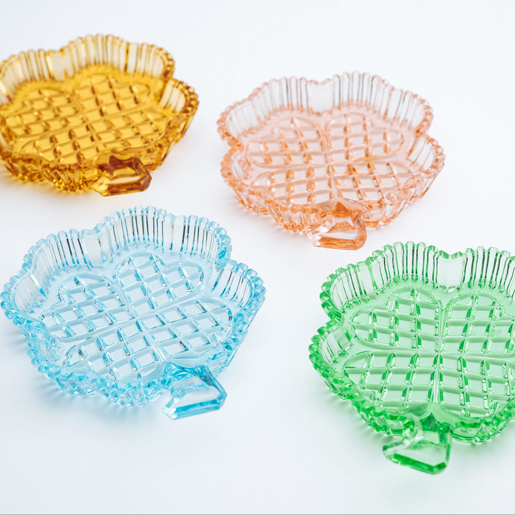Four colorful clover shaped dishes on a white background