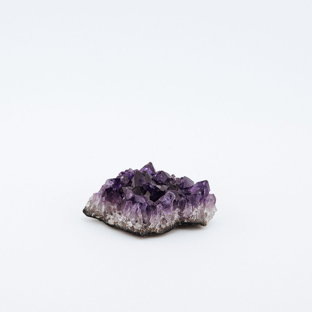 Amethyst crystal cluster on a white background