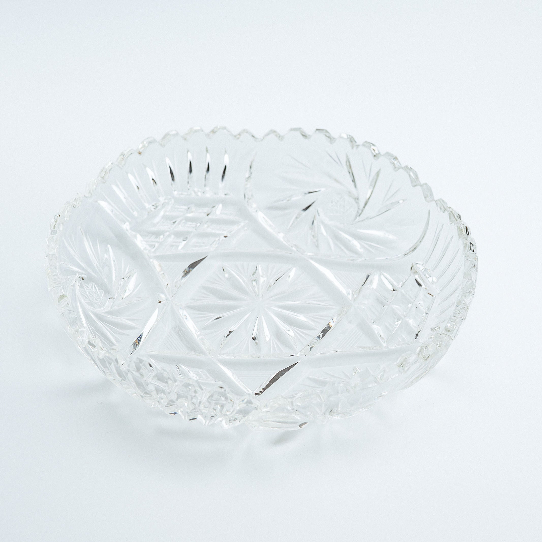 Clear glass bowl with decorative pattern on a white background