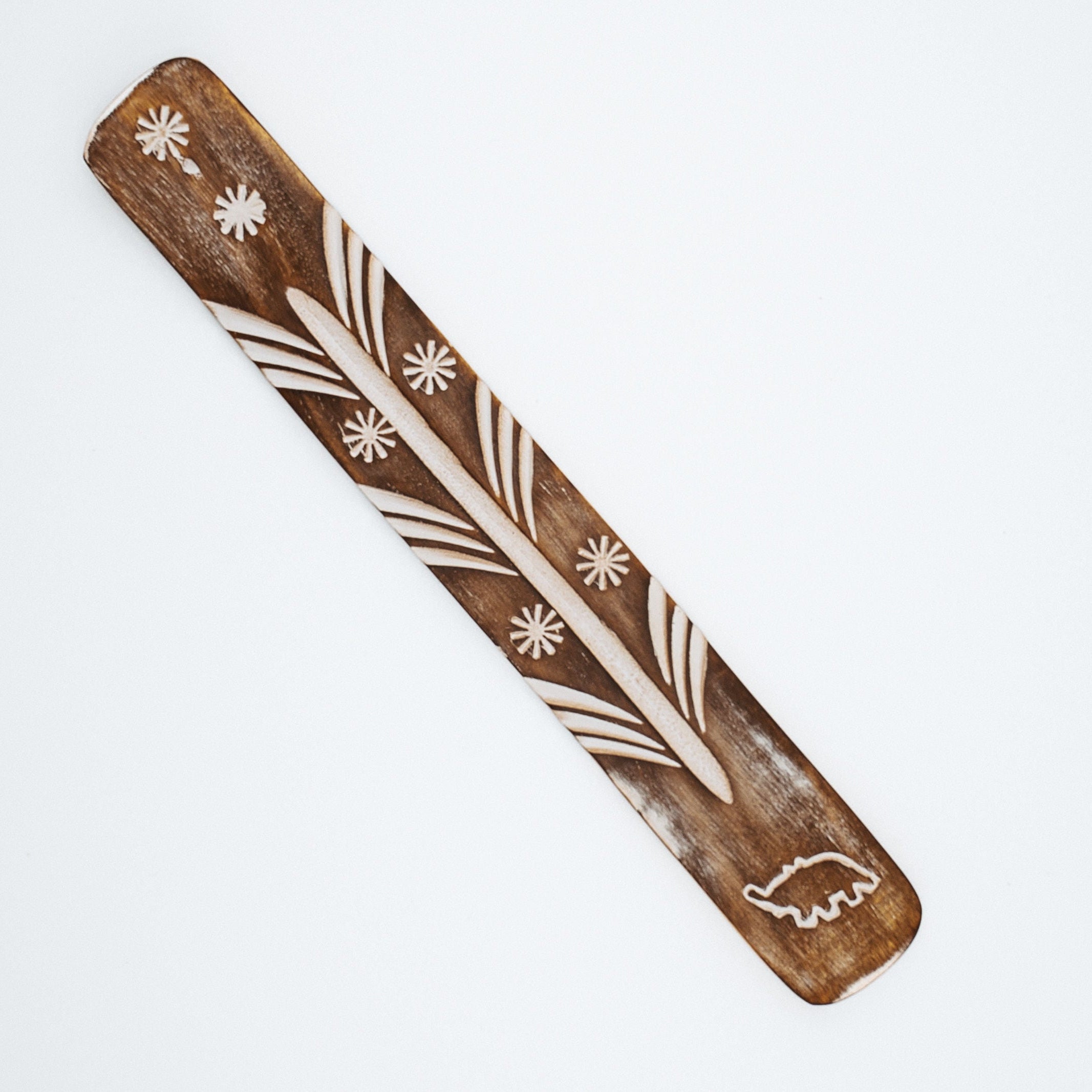 Wood piece with elephant design on a white background