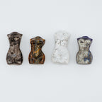 Four small stone figurines women's bodies on a white background
