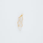 Gold clear pendant on a light gray background