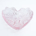 Heart-shaped glass bowl with pink tint on a white background