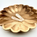 long wand shaped clear stones on wooden bowl