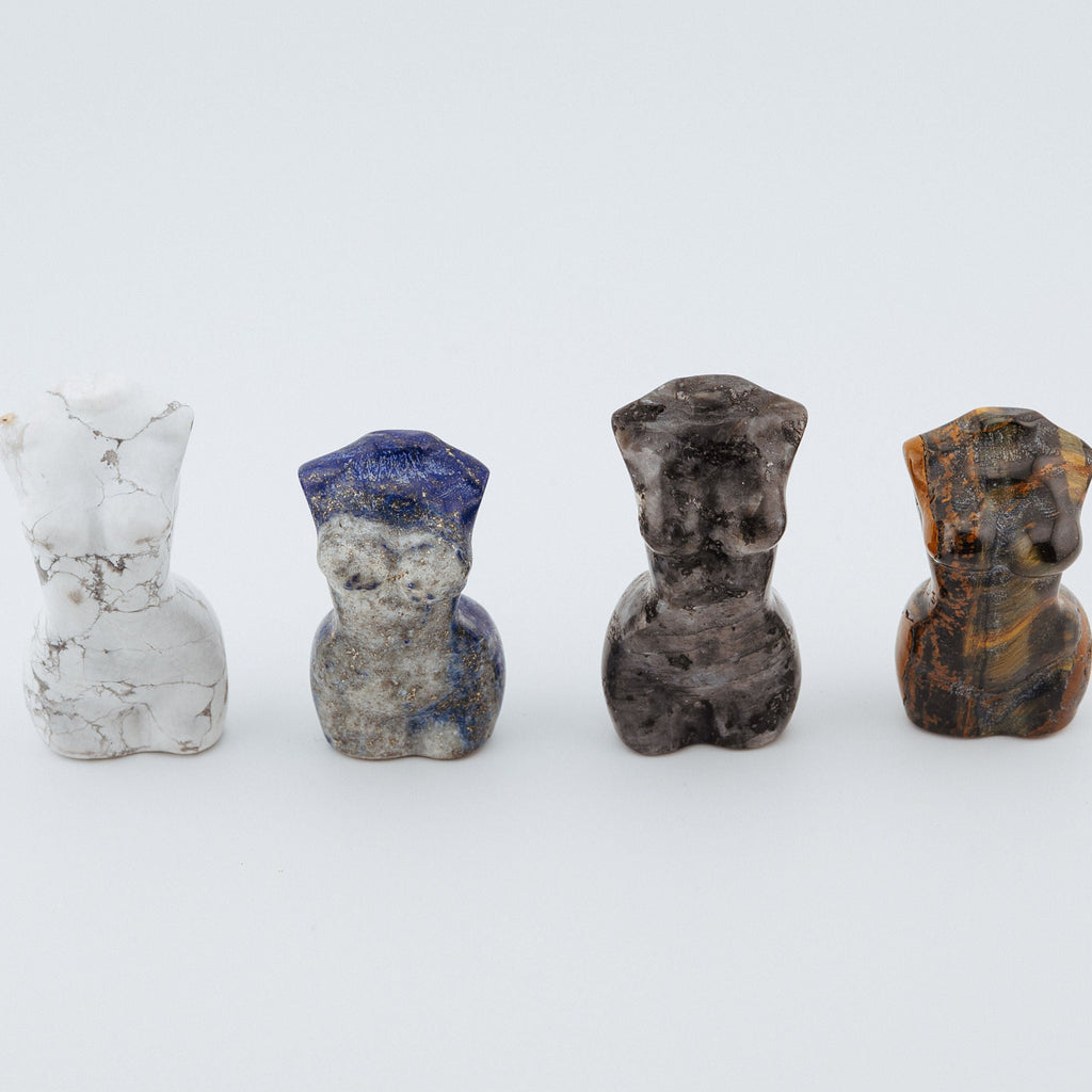 Four small stone sculptures on a white background