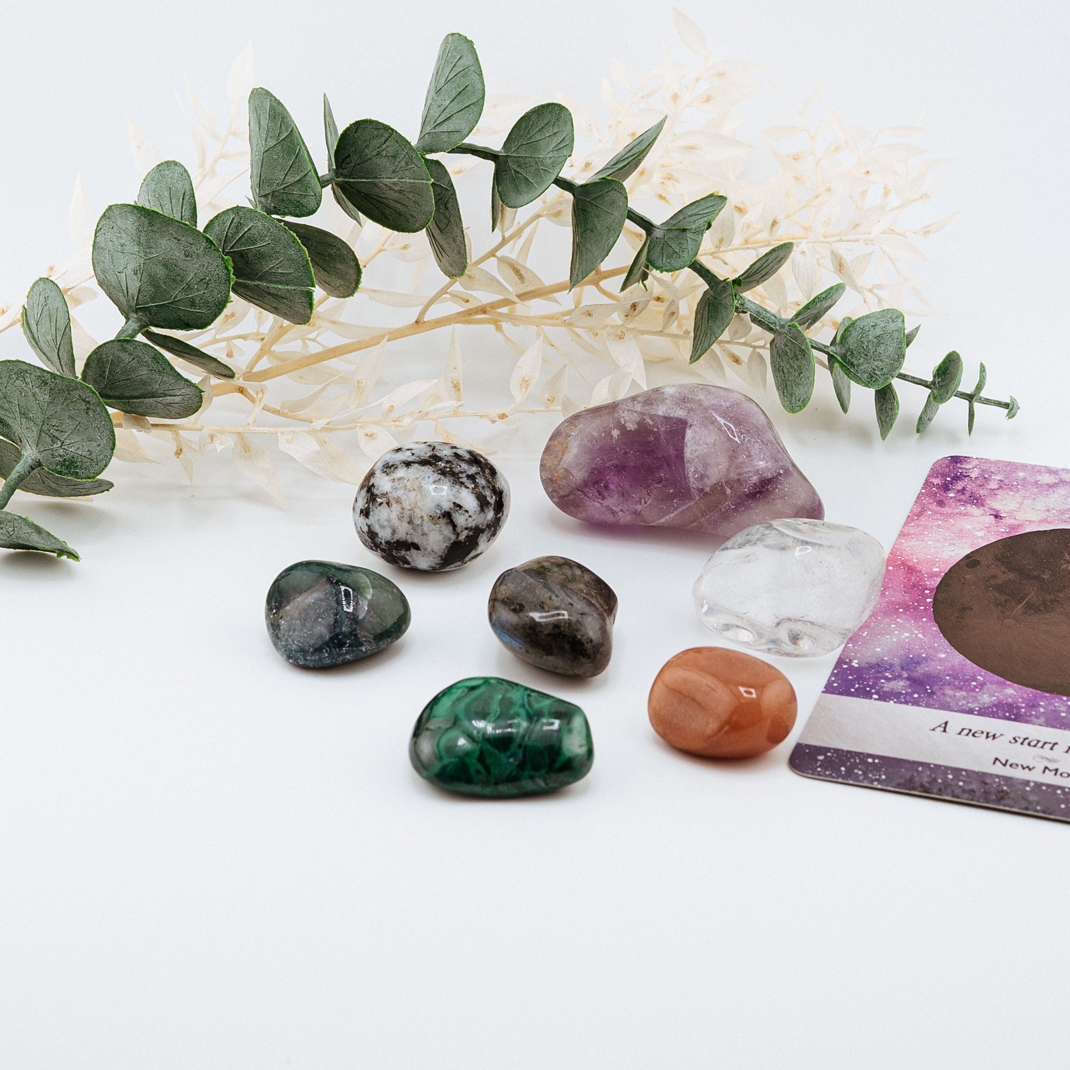 Set of colorful crystals and a tarot card with a white background