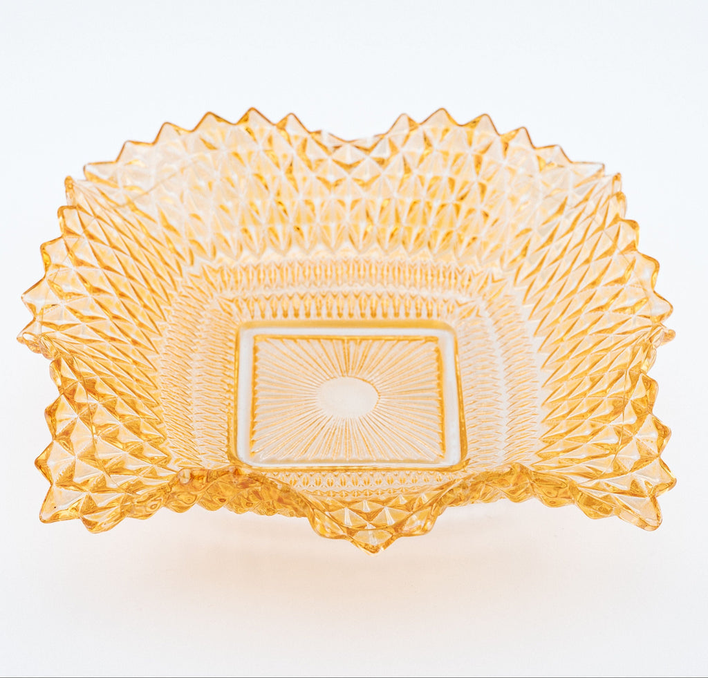 Decorative glass bowl with intricate patterns on a white background