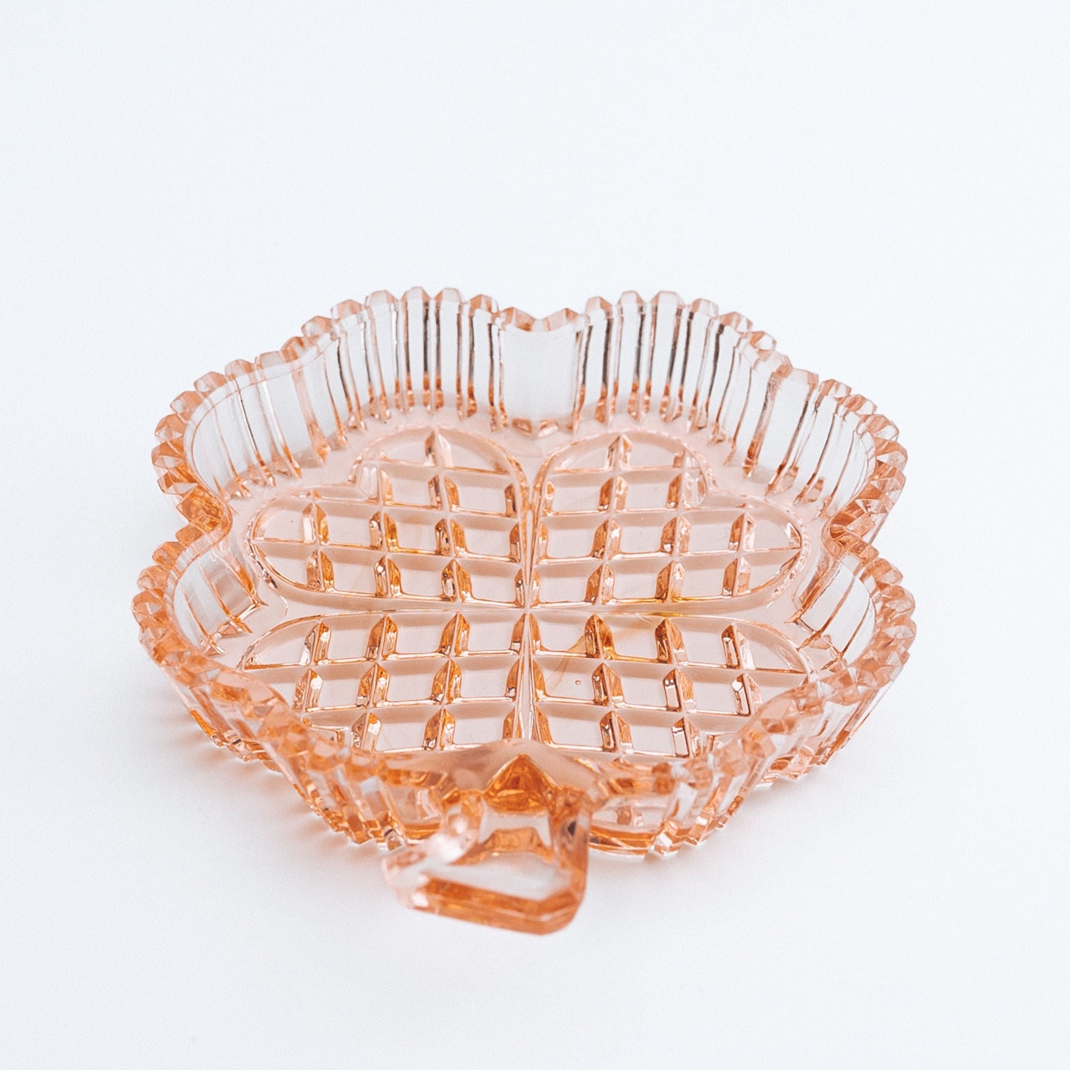 Pink clover shaped dish on a white background