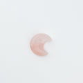 Pink crescent moon-shaped stone on a white background