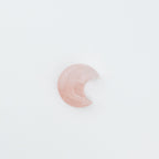 Pink crescent moon-shaped stone on a white background