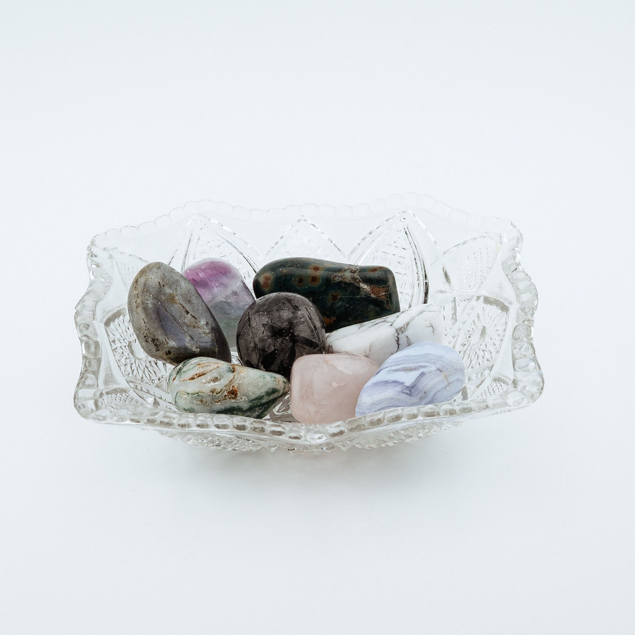 Glass bowl with stones inside on a white background
