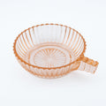 Pink glass bowl with a handle on a white background