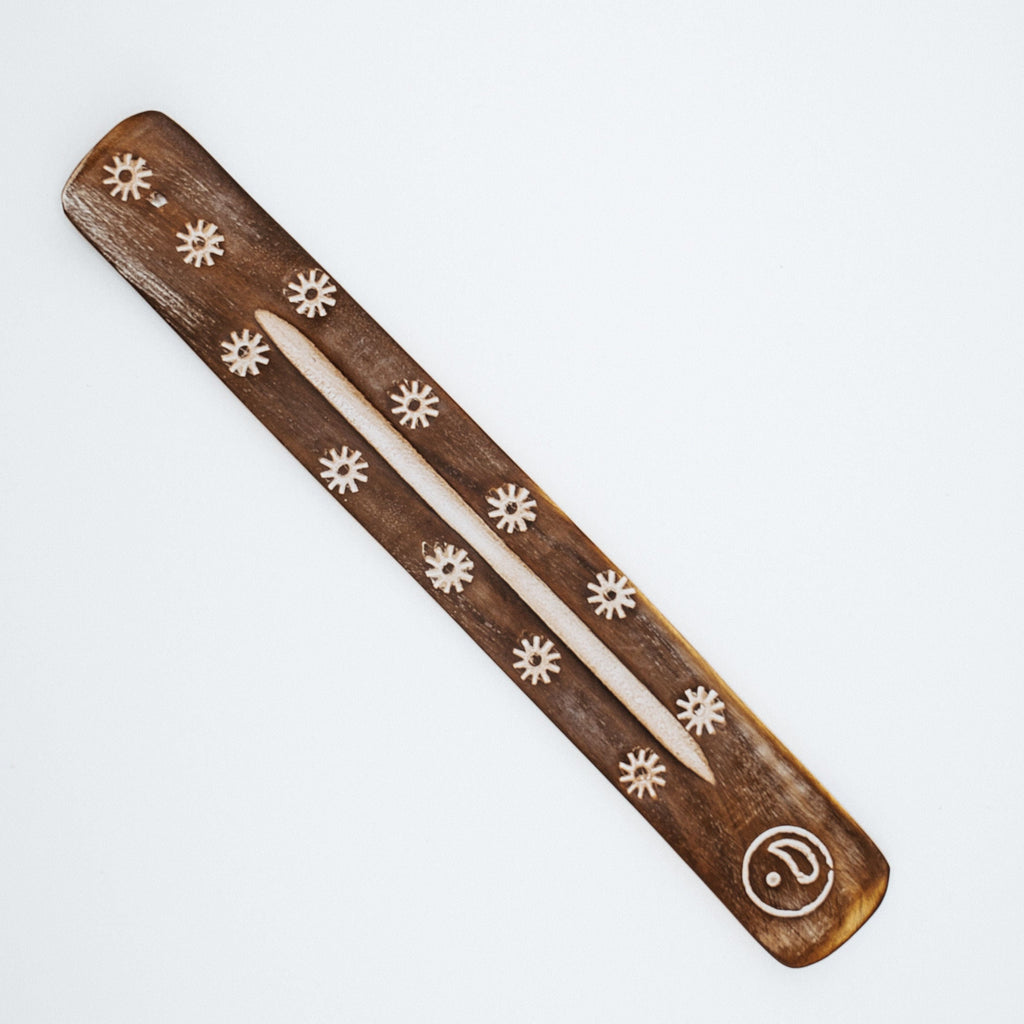 Wood piece with flower and circle design on white background