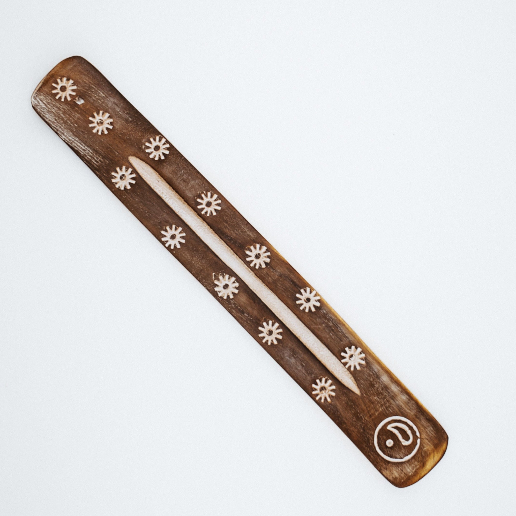 Wood piece with flower and circle design on white background